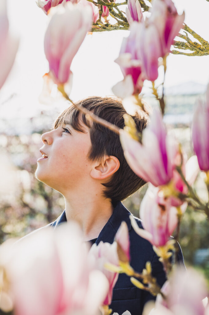 Communie en lentefeest fotografie jongen tussen de bloesems